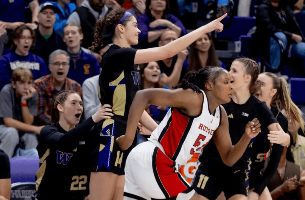 UW forward Dalayah Daniels points to an assister and celebrates with the bench after hitting a three-point shot against Rutgers on February 20, 2025 at Alaska Airlines Arena in Seattle, Wash.